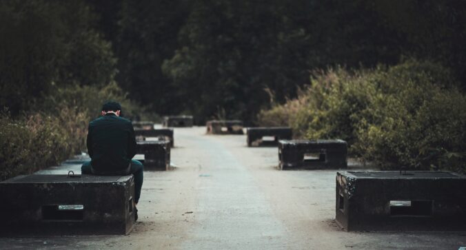 Person sitting alone with empty benches