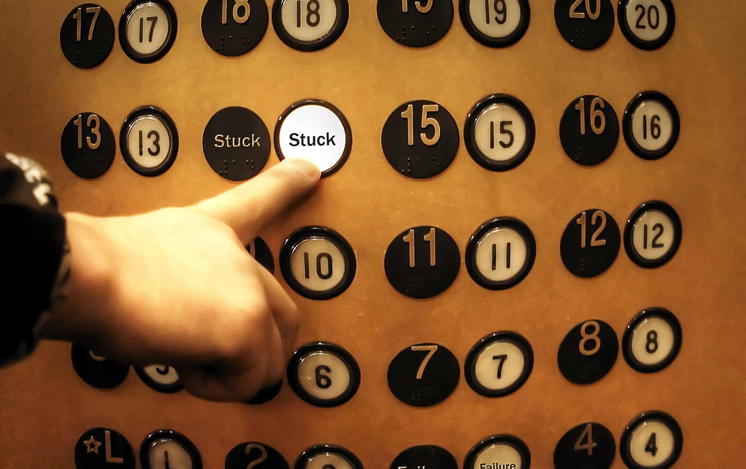 A hand selects "Stuck" on a set of elevator buttons